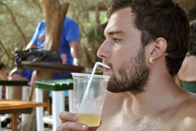 Portrait of young man drinking glass