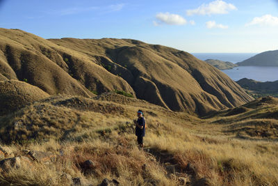 Man standing on mountain against sky