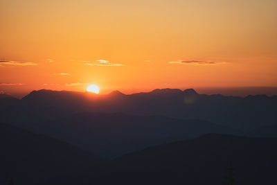 Scenic view of silhouette mountains against romantic sky at sunset