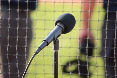Close-up of microphone against fence