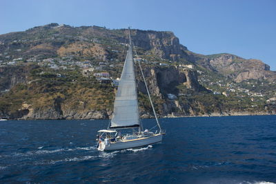 Boat sailing on sea against clear sky