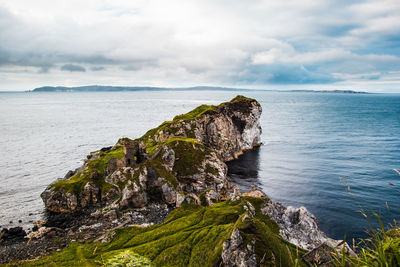 Rock formations by sea against sky