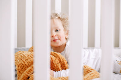 Cute adorable baby boy toddler lying in crib at kids nursery room at home. funny charming baby boy 