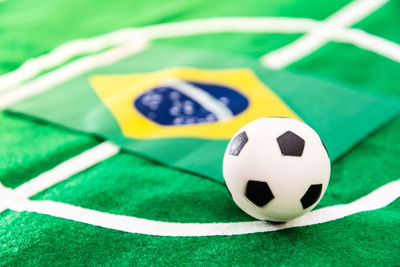 Close-up of small soccer ball with flag on green textile