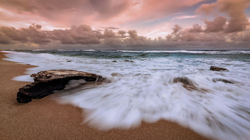 Scenic view of beach against sky during sunset