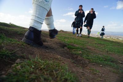 Low section of people walking on field