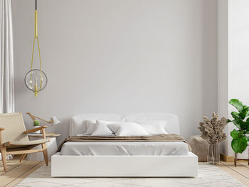 White bedroom with armchair on the wall in home bedroom interior.3d rendering