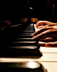 Cropped hands of person playing piano