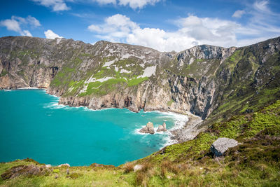 Scenic view of sea and mountains against sky