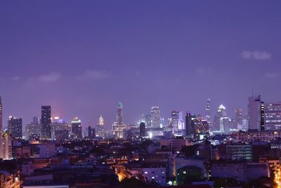 Illuminated cityscape against sky at night