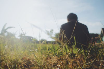 Rear view of man on field against sky