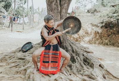 Rear view of man sitting on sand at beach