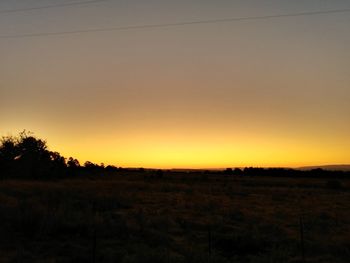 Scenic view of field against clear sky during sunset