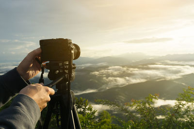 Midsection of man photographing against sky