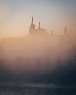 Vltava river by prague castle during foggy sunset