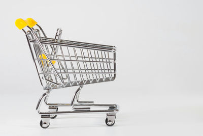 A close-up of an empty shopping cart at the white background with the empty space for texting