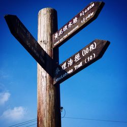 Low angle view of signboard against clear blue sky