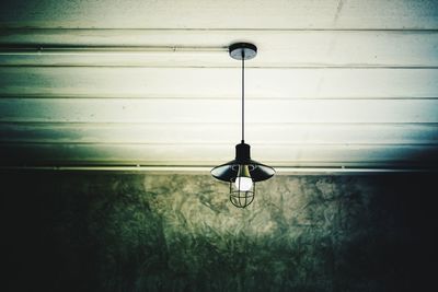 Close-up of electric lamp against wall