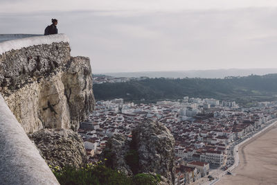 People looking at cityscape against sky