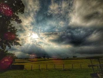 Scenic view of field against storm clouds