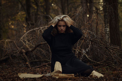 Portrait of young woman siting in forest