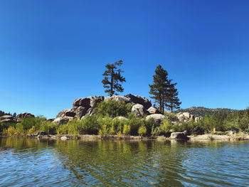 Scenic view of lake against clear blue sky