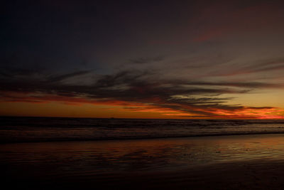 Scenic view of sea against dramatic sky during sunset