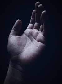 Close-up of human hand against black background