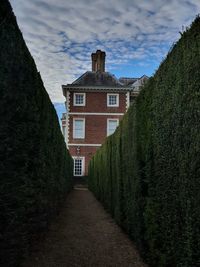 Houses amidst trees and buildings against sky