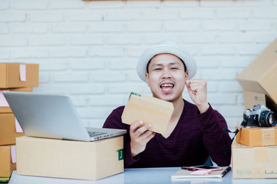 Portrait of smiling young woman using mobile phone in box