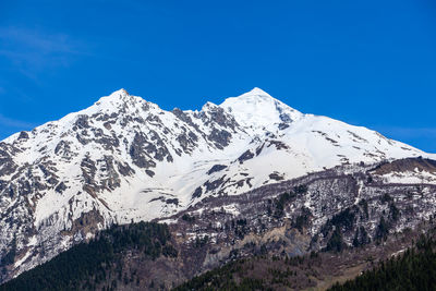 Scenic view of snowcapped mountains against clear blue sky