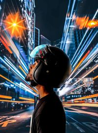 Portrait of man with light trails in city at night