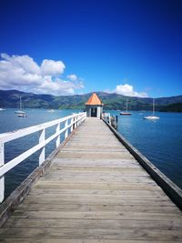 Pier over sea against blue sky