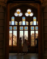 Rear view of people on glass window of building