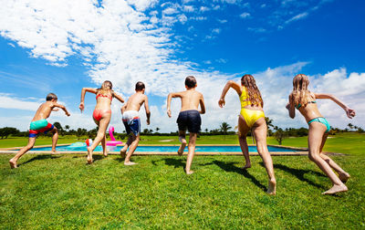 Group of people at beach against sky