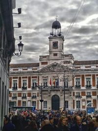 Tourists in front of building against sky