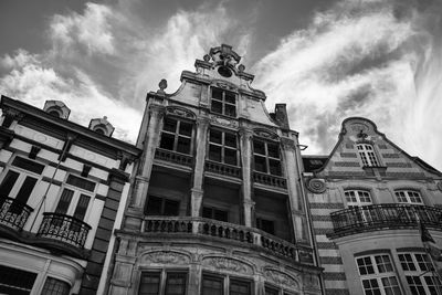 Low angle view of buildings against cloudy sky