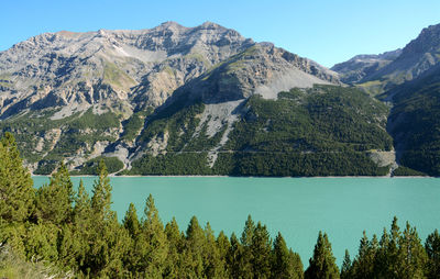 Scenic view of lake and mountains against blue sky