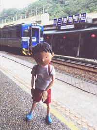 Full length of boy standing at railroad station