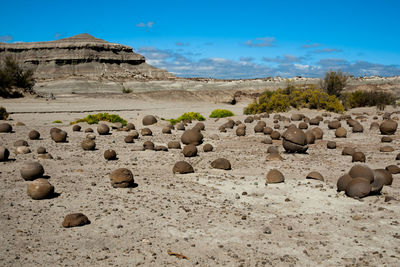 Rocks on arid landscape against sky