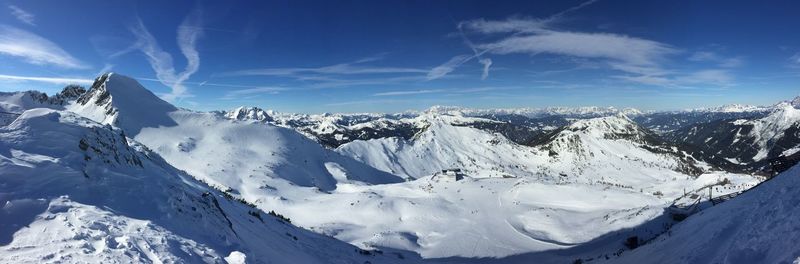 Panoramic view of snowcapped mountains against blue sky