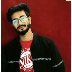 Young man wearing eyeglasses against red background