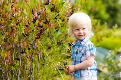 Smiling boy standing by plants