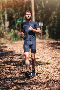 Full length portrait of man jogging in forest