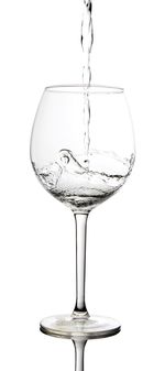 Close-up of water splashing in glass against white background