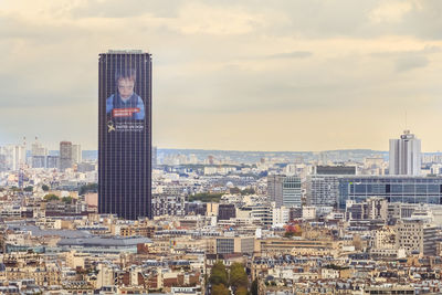 Buildings in city against cloudy sky