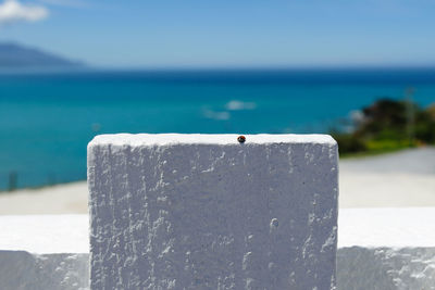 Close-up of retaining wall by sea against sky