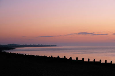 Scenic view of sea against romantic sky at sunset