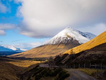 Scenic view of mountains against cloudy sky