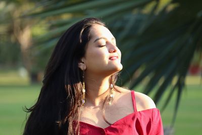 Portrait of young woman looking away outdoors